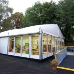 A temporary building used as a classroom structure surrounded by trees and outdoor play areas.